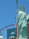 The Statue of Liberty in front of the New York, New York hotel, with the roller coaster in the background.